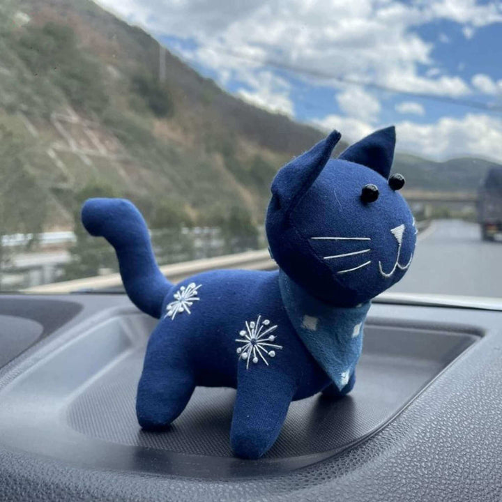 Plant dyed indigo cat toy on car dashboard, handmade natural cotton fabric stuffed animal doll